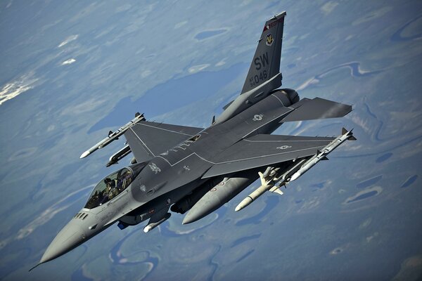 F-16 military aircraft on the background of the ground from a height