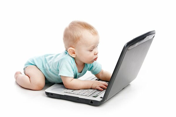 Un bambino piccolo guarda attentamente nel monitor del laptop