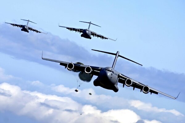 3 planes drop cargo in the sky