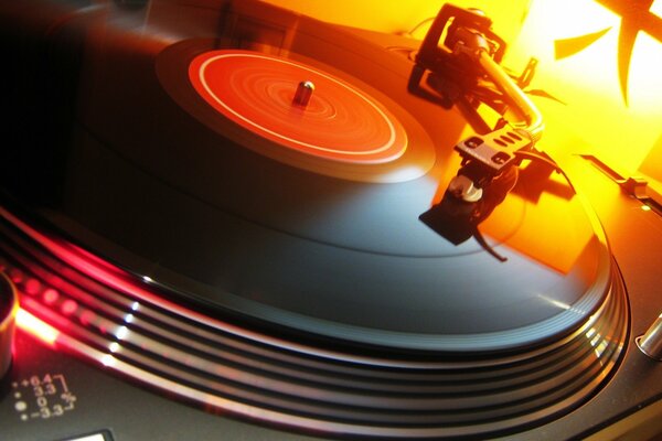 Sul giradischi, un disco in vinile in una luce arancione