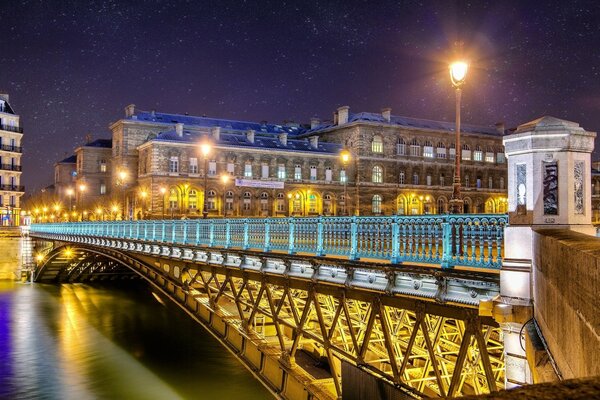 Brücke über dem Nachtfluss vor dem Hintergrund der Pariser Architektur