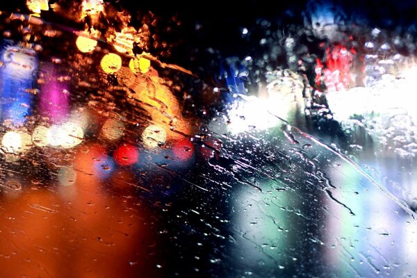 Immagine di luci notturne sullo sfondo di gocce di pioggia