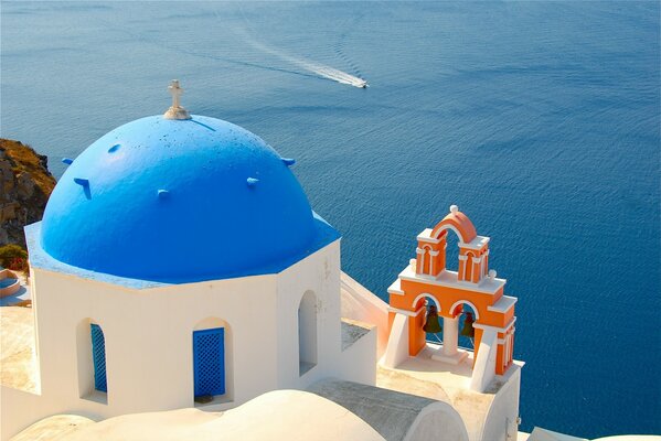 Santorini. Foto einer Kirche mit einer blauen Kuppel auf dem Hintergrund der Ägäis