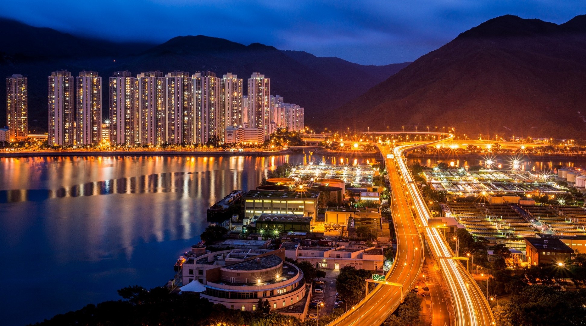 luci hong kong cina grattacieli panorama strada città di notte montagne