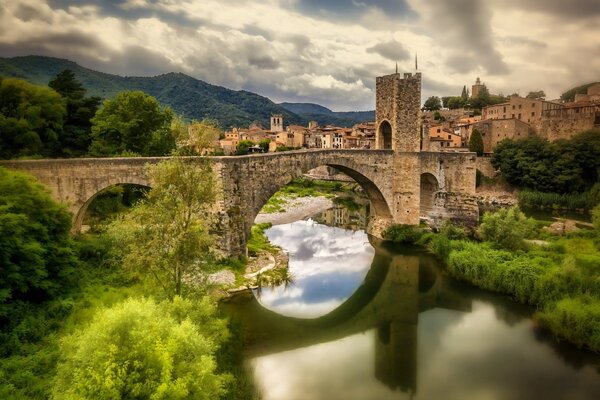 Reflejo del puente de piedra en el río fluvia