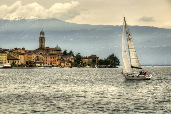 Yacht sullo sfondo delle montagne, navigando sul lago di Garda