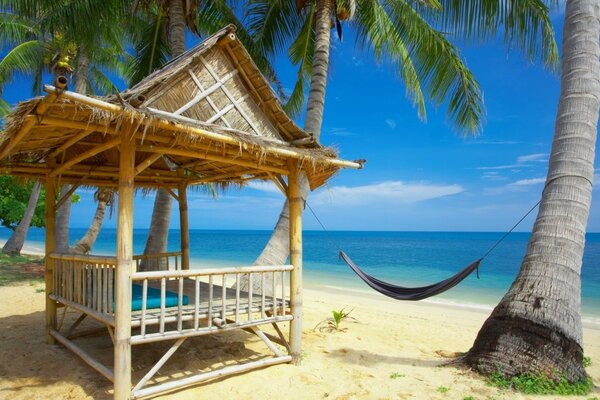 Détente gazebo près de l océan sur la plage avec hamac vacances ensoleillées