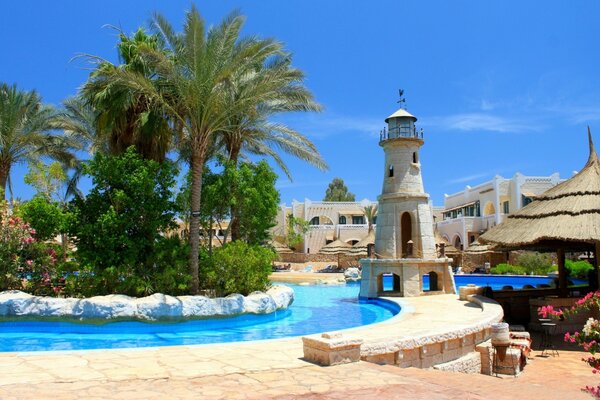 Outdoor swimming pool with decorative lighthouse in the hotel