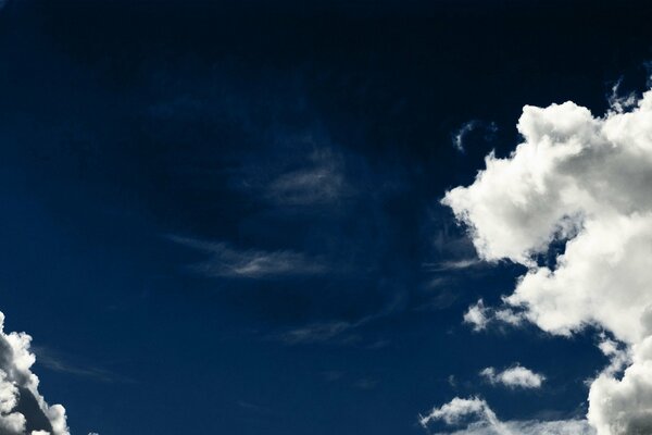 Ciemnoniebieskie niebo z białymi chmurami
