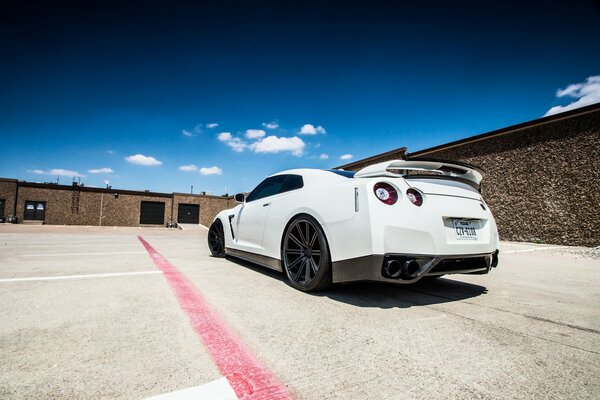 Blanc Nissan r35 vue arrière sur fond de ciel et de nuages