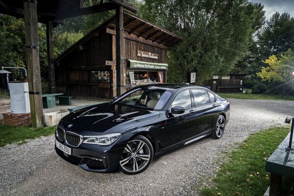 Voiture noire BMW sur un vieux parking avec Grange