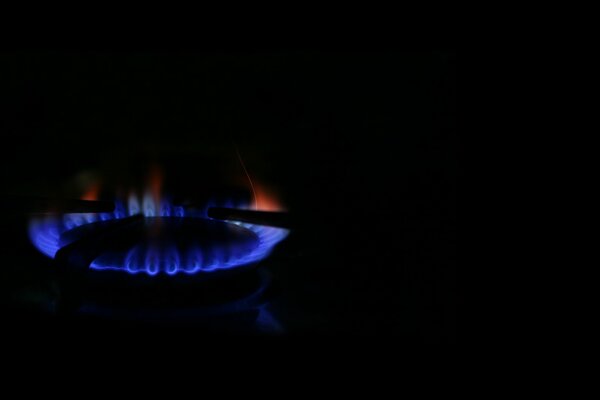 Gas burner on a black background. Blue and red flames