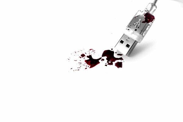 Filo Usb cosparso di vernice rossa su sfondo bianco