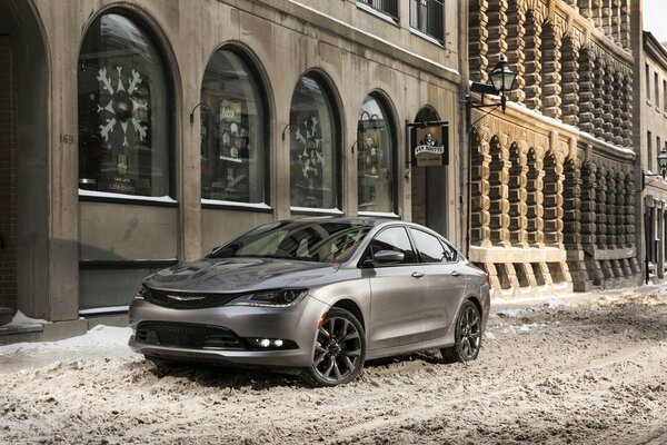 Chrysler 200c hat im Winter in der Nähe des Gebäudes geparkt