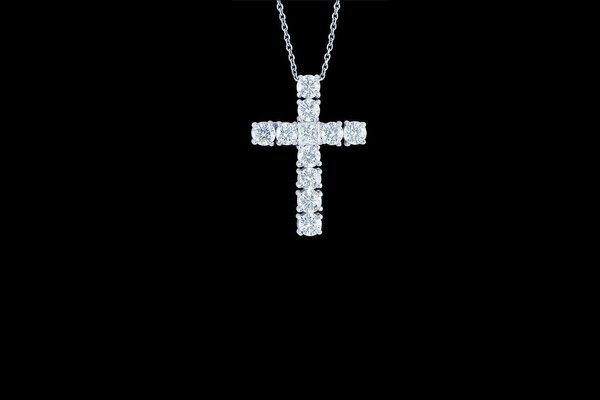Серебряные цепочка и крест на чёрном фоне