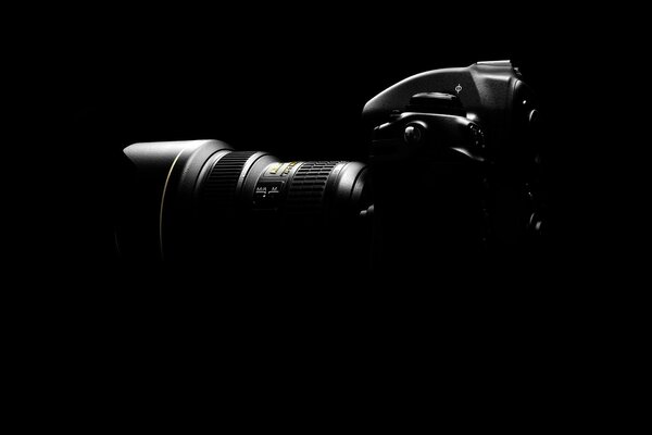 A modern camera with powerful optics on a black background