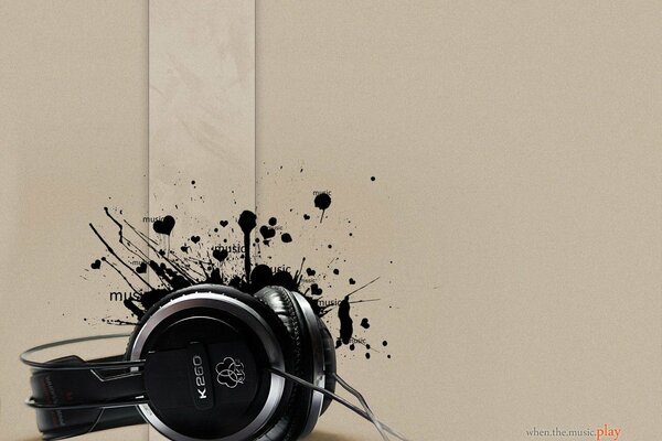 Headphones on a beige background with a blot