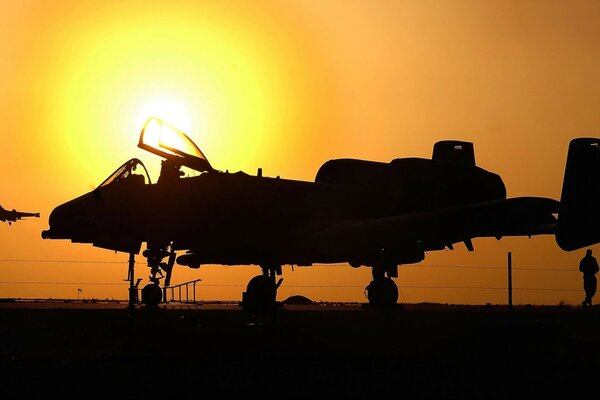 Foto eines Militärflugzeugs bei Sonnenuntergang