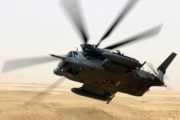 Helicopter flying over the desert during the day