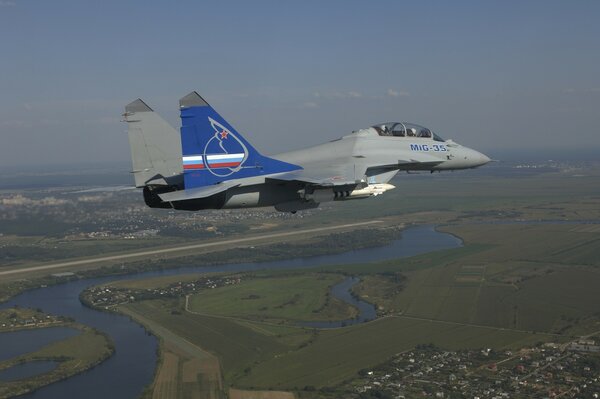 The mig-35 fighter is flying high above the ground