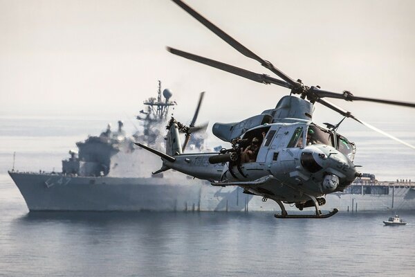 A combat helicopter shoots at an aircraft carrier