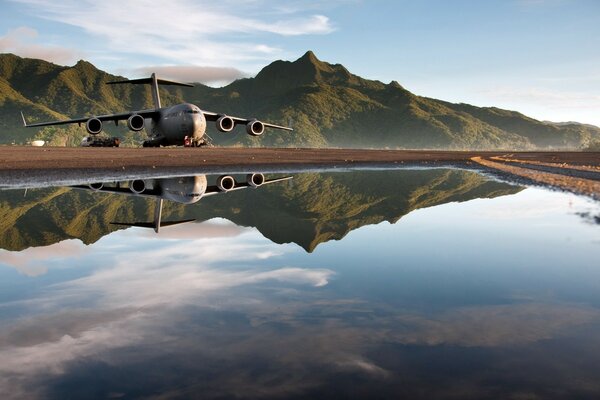 A huge plane in flight and in the reflection of water