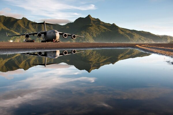 Enorme avión en vuelo y en el reflejo del agua