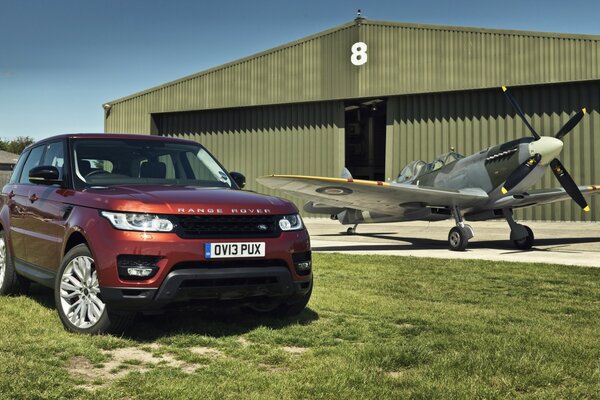 Le Range rover rouge se tient près du hangar et de l avion