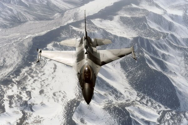 Samolot wojskowy przelatuje nad zaśnieżonymi górami