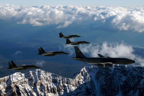 Los aviones vuelan en las nubes sobre las montañas