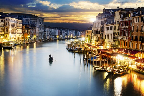 Mann auf einem Boot, der den Kanal von Venedig entlang schwimmt