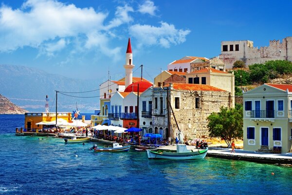 Paseo marítimo con casas de colores y barcos