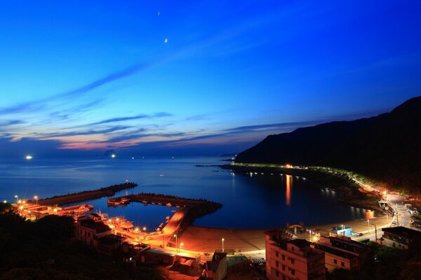 Città notturna vicino al mare. Tramonto