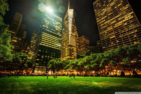 Un parque en nueva York con un rascacielos por la noche