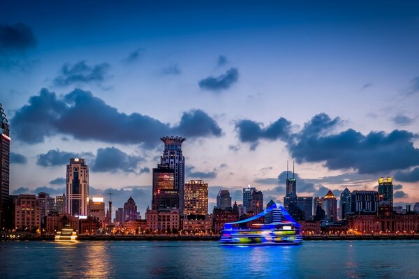 The lights of Shanghai at night in China. The city above the river