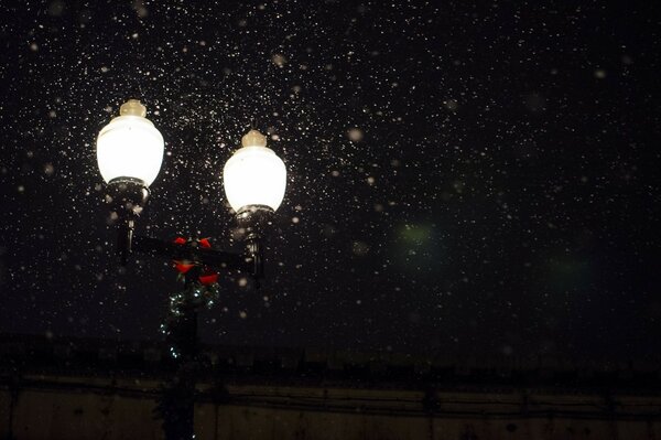 Night lantern emitting light under the snow