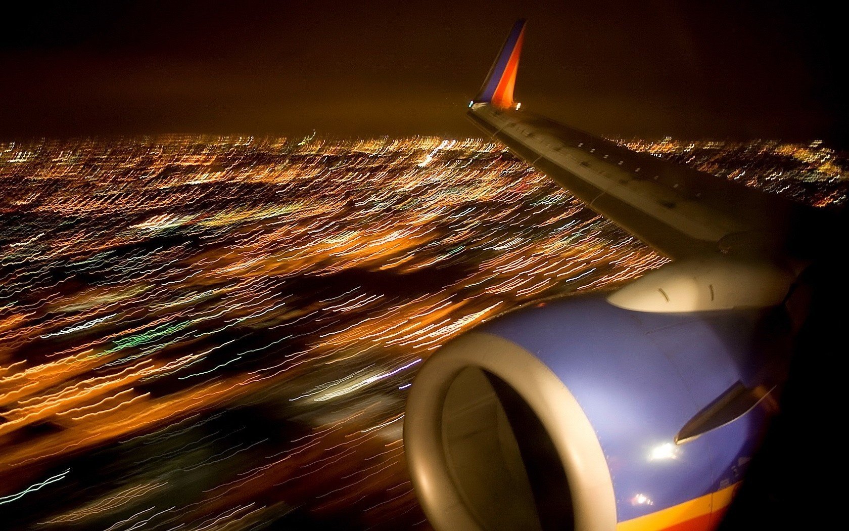 verschwommene ansicht flugzeugflügel flug in der nacht turbine stadtlichter flugzeug flugzeug luftverkehr