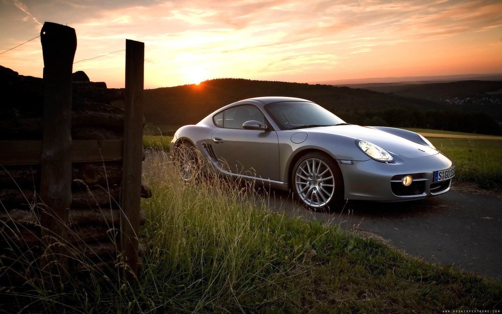 porsche cayman серый порше за городом закат горизонт авто серебристое авто трава машина легковые авто транспорт автотранспорт вечер фара свет поле холмы дрова