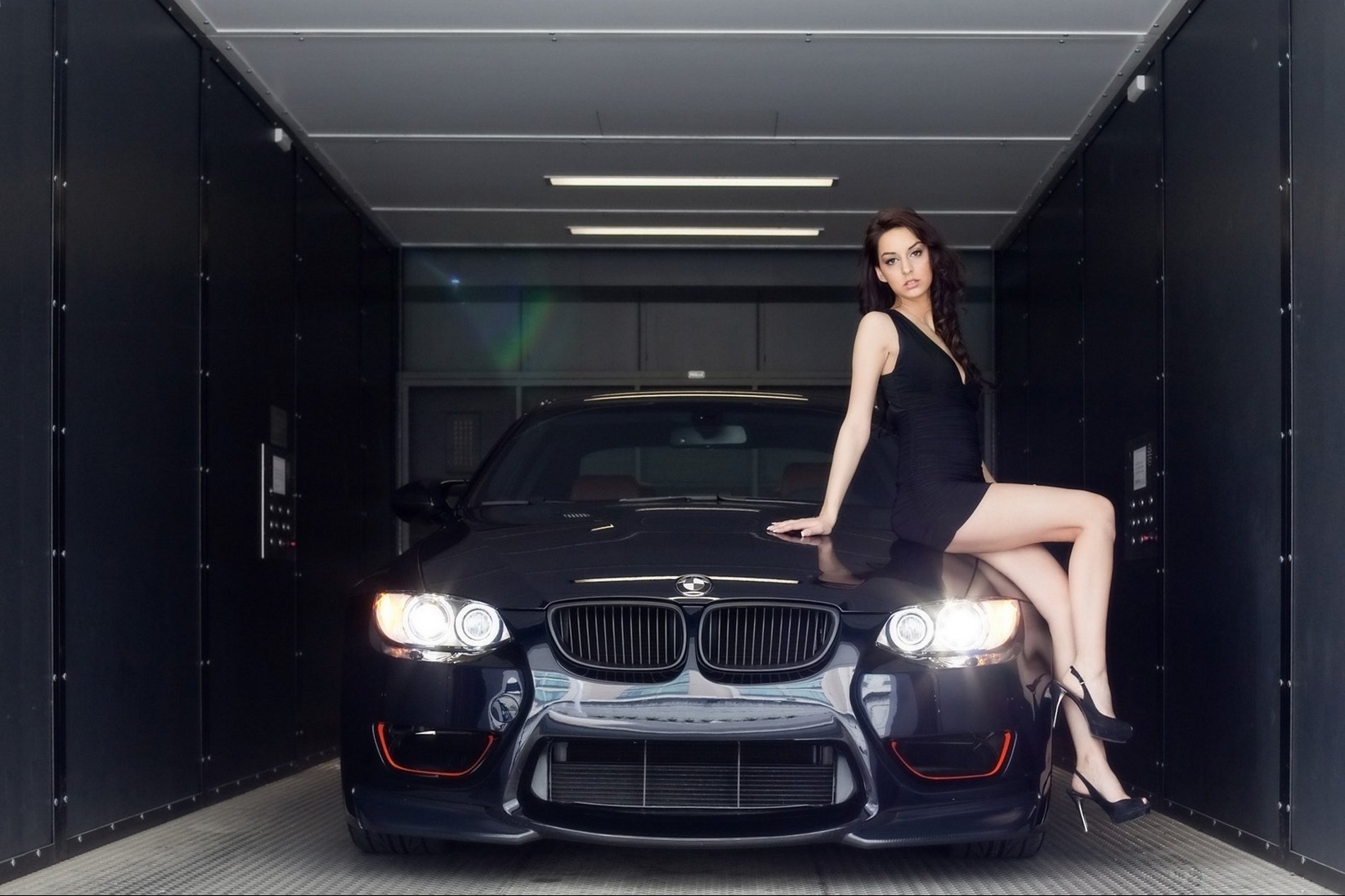 i nuovi cinque neri accovacciati sul cofano slegonets belle gambe bmw ragazza in nero in garage ragazze trasporti auto automobili veicoli donne