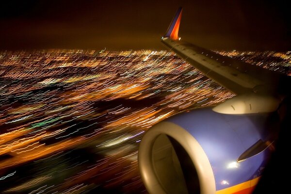 Vue depuis le Hublot sur l aile de l avion et les lumières de la ville