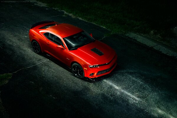 Chevrolet Camaro rouge sur une route sombre