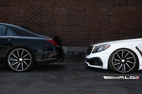 Two Mercedes on the background of a brick wall