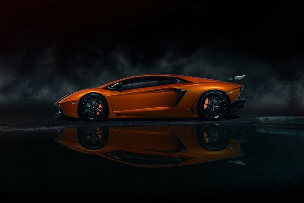 Profile of an orange Lamborghini on a black background