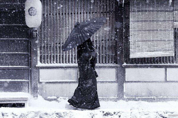 Desktop Japanese woman walks under the snow with an umbrella