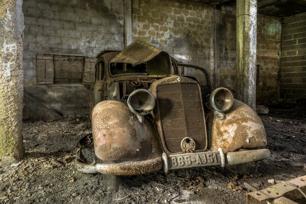 An old rusty car in the garage