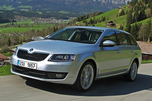 Skoda color argento su uno sfondo di montagne verdi