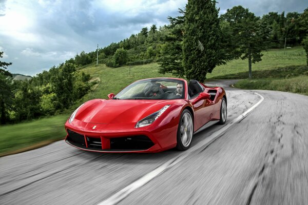 Red Ferrari convertible on a country road