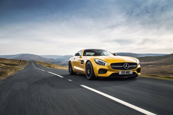 A yellow Mercedes driving on the road