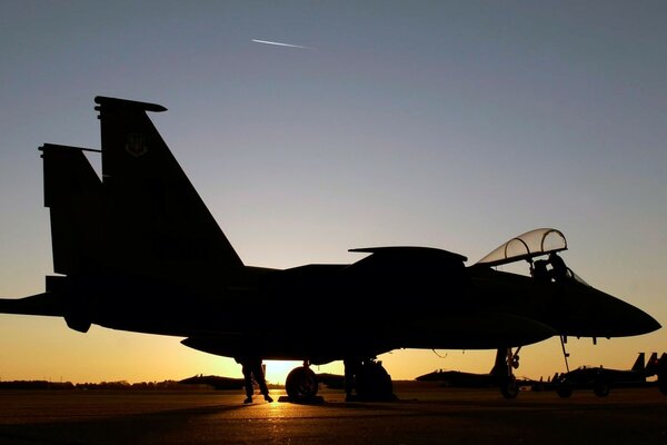 Chasseur f-15 à la base pendant le coucher du soleil