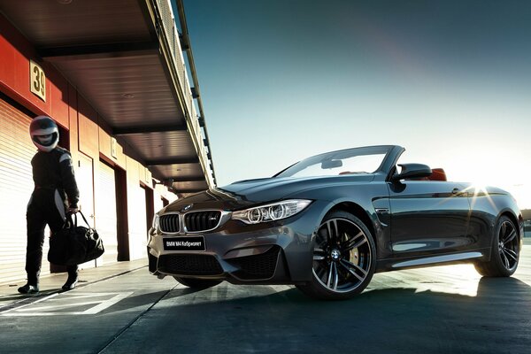 BMW convertibile grigio scuro con pilota